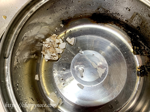 3.砕いた玉子の殻を焦げの上にセットし、焦げを殻で擦る
